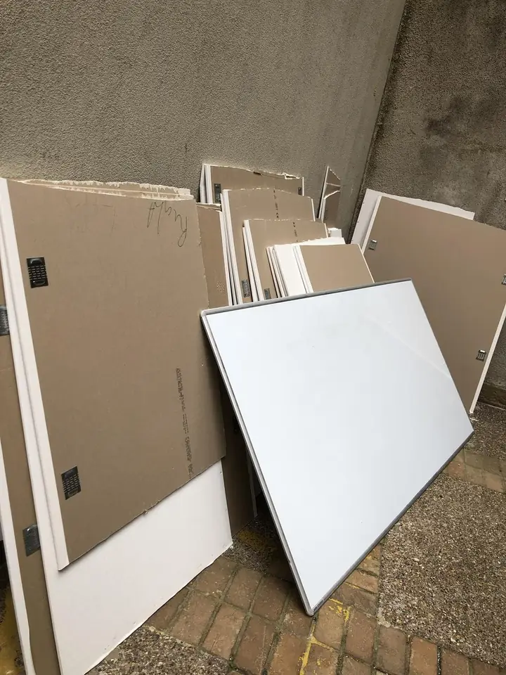 Before: Old boards and a whiteboard in a yard. Cleared.